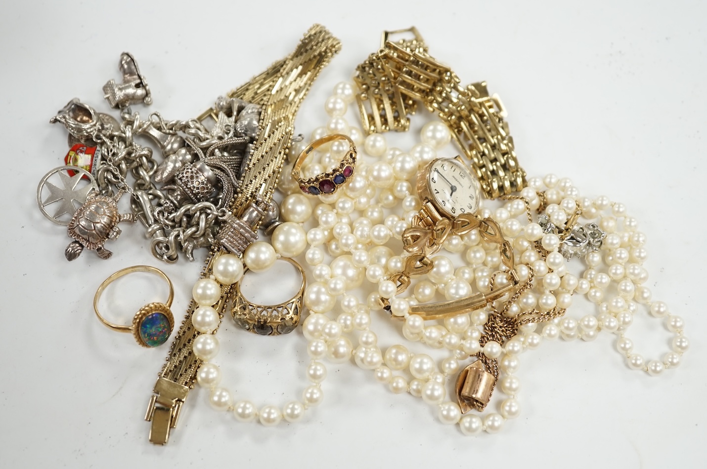Four assorted modern 9ct and gem set rings, a 9ct and gem set pendant, a 9ct chain with yellow metal pendant, a silver charm bracelet and a small quantity of costume jewellery. Condition - poor to fair